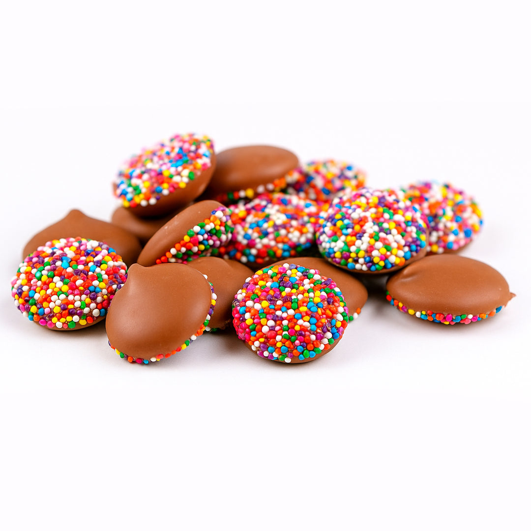 Chocolate candies with colorful sprinkles on a white background